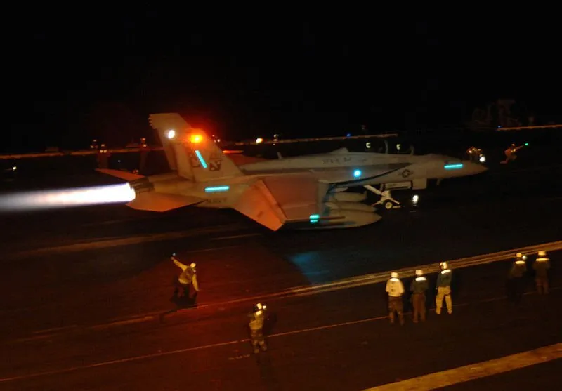 U.S. fighter jets taking off from an aircraft carrier at night